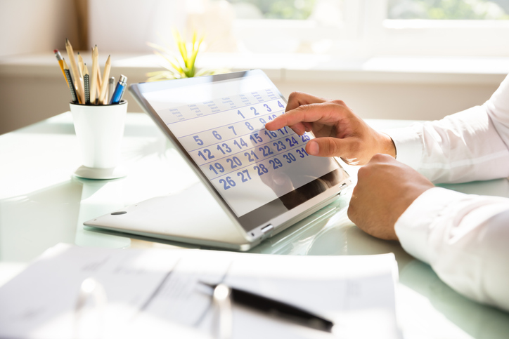 Staggered check-in Businessman using calendar on laptop