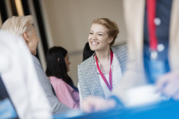 Back to face-to-face trade shows, businesswoman shaking hands at a trade show