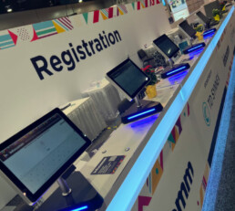 Row of computers for attendees to easily check in at event, streamlined check in experience